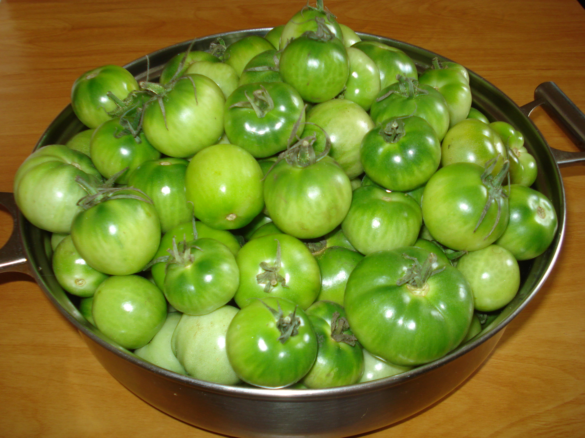 Зеленые мелкие помидоры в чашке на столе